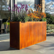 Rusty metal planter with flowers on a patio